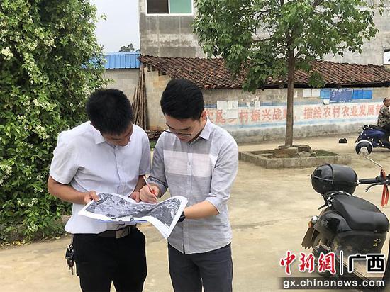 头塘村的驻村工作队员和党支部书记讨论风貌提升规划。何凯 林萍  供图
