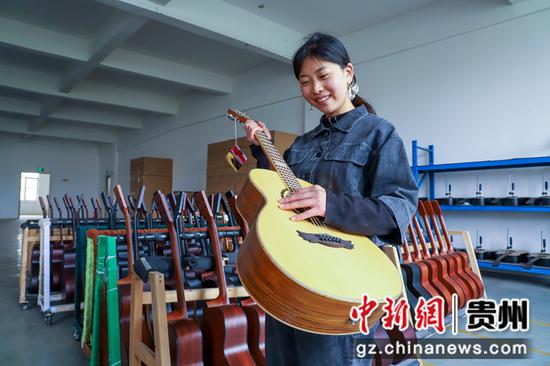2021年4月11日，在贵州省黔西县文峰社区岔白工业园区多马可乐器厂车间里，工人正在 检验吉他音色。