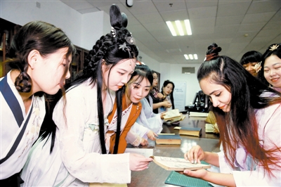 图为学生们在老师指导下，身穿汉服，阅读典籍，体验中华传统文化之美。 记者 张立摄
