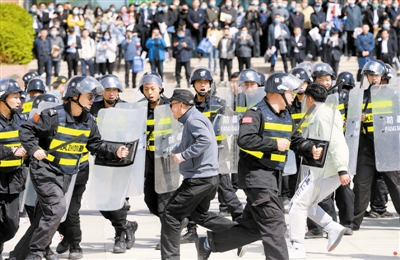 上图 天津理工大学保安队现场进行校园反恐防暴应急演练。 记者 张立摄