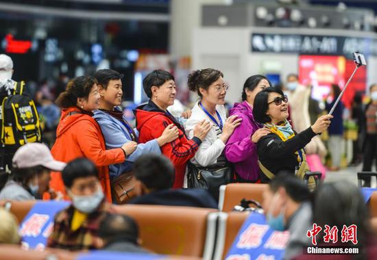 图为乘坐专列的旅客在候车大厅里拍照留念。中新社记者 刘新 摄