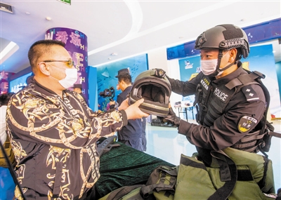 图①  特警向市民展示先进的反恐装备。   本报记者  曹彤摄