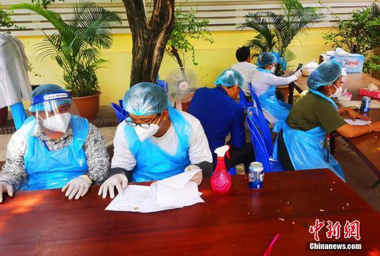 当地时间4月16日，记者从金边王家军总医院获悉，自“春苗行动”在柬埔寨正式启动后，已有大批在柬中国公民完成新冠疫苗接种第一针，目前该计划正在顺利实施中。图为柬方工作人员审核材料。 中新社记者 欧阳开宇 摄