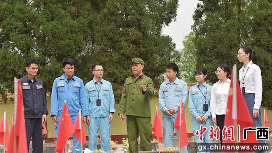 傅金荣在烈士陵园祭英烈时向团员青年讲述党史故事。易欢 摄