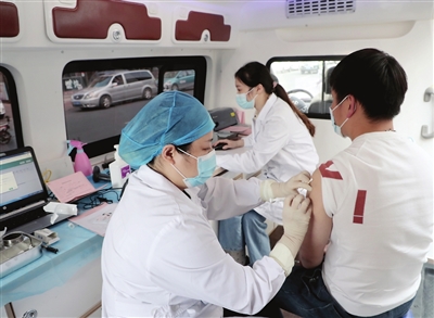 商户在移动接种车内接种新冠病毒疫苗 摄影 刘泽瑞