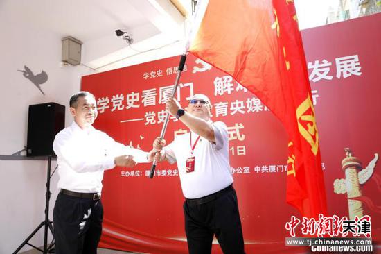 厦门市委常委、宣传部部长李辉跃（左）为采访活动授旗。　李思源　摄