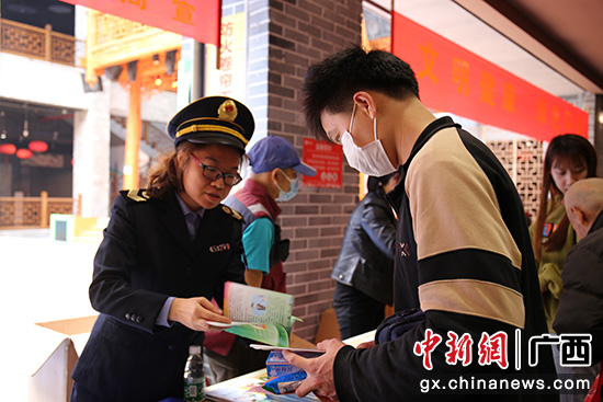 图为党员志愿者向群众发放健康宣传资料。 熊晶 摄 桂林阳朔县启动爱国卫生月主题宣传活动