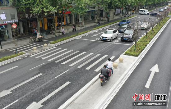 市民骑车在“Z”形斑马线中间的“缓冲区”停车观察对向来车（无人机照片）。  王刚 摄