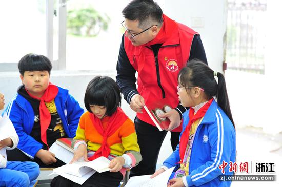 温岭市烟草专卖局党员突击队将红色书籍送给学生。  潘琦 摄