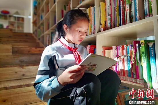 图为当地儿童在三宝儿童图书馆开馆当日看书学习。　张冬冬　摄