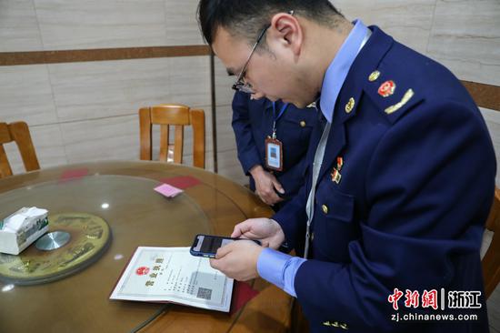 扫描营业执照二维码了解商户情况  王建明 摄