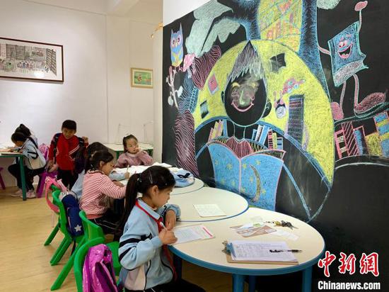 图为当地儿童在三宝儿童图书馆开馆当日看书学习。　张冬冬 摄