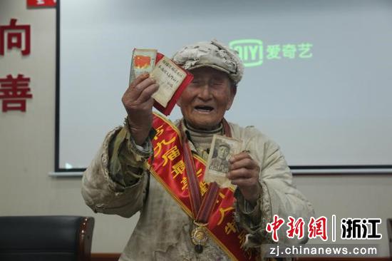 余元利老人向武警官兵展示所获得的荣誉。陈铭泽 摄
