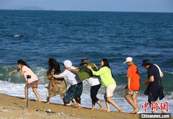 5月3日，游客在三亚南山文化旅游区海边游玩。　陈文武 摄