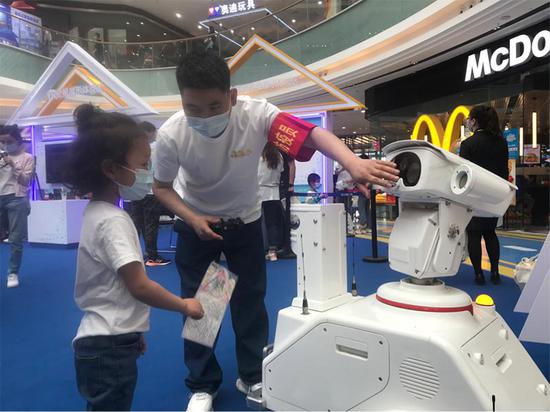 工作人员向小朋友介绍智能巡检机器人。