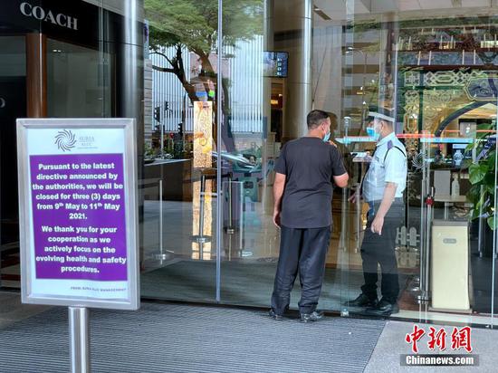 当地时间5月9日，吉隆坡阳光广场安保人员向市民解释商场已暂时关闭。马来西亚政府根据其开发的疫情预测系统，于8日宣布151个潜在疫情感染热点，其中吉隆坡就占66个，多家入列的知名商场宣布9日起关闭三天。 中新社记者 陈悦 摄