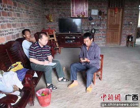 工作人员到卢桂德家了解情况。金秀县委宣传部供图