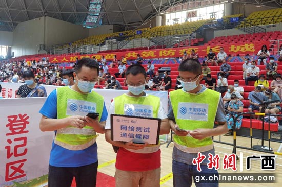 在百色靖西市的体育馆，中国移动广西公司技术专家正在疫苗接种场地检查网络信号质量。陈一蓓 摄