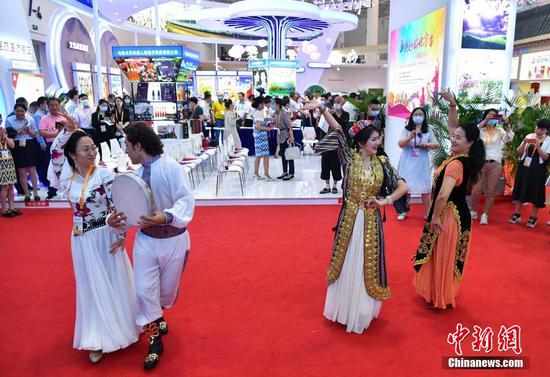 5月8日，海南省海口市，首届中国国际消费品博览会举行新疆日活动，推介新疆名优产品。图为来自新疆的舞者在活动开始前表演舞蹈。 中新社记者 崔楠 摄

