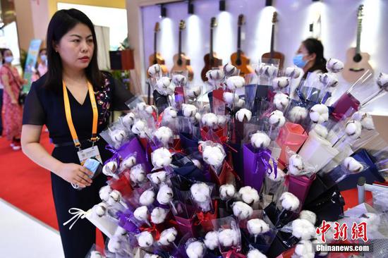 
5月8日，海南省海口市，首届中国国际消费品博览会举行新疆日活动，推介新疆名优产品。图为来自新疆的工作人员在现场整理将要派发的棉花花束。 中新社记者 崔楠 摄