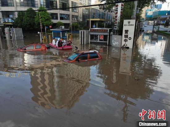 图为贵阳珠江路附近道路严重积水，消防员展开救援。　郑宇 摄