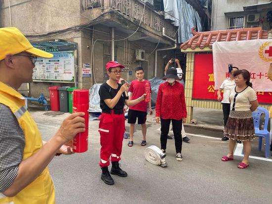 中志协应急委广西服务队志愿者为居民讲解消防器材使用方法。覃宝琳 摄