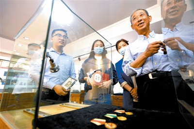 图1 韩放（右1）、韩文昱（右4）父子在展览现场介绍韩蕴菖老人的革命经历及奖章背后的故事。 记者 庞剑摄