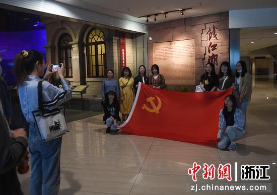 参观者在展览现场与党旗合影。王刚 摄