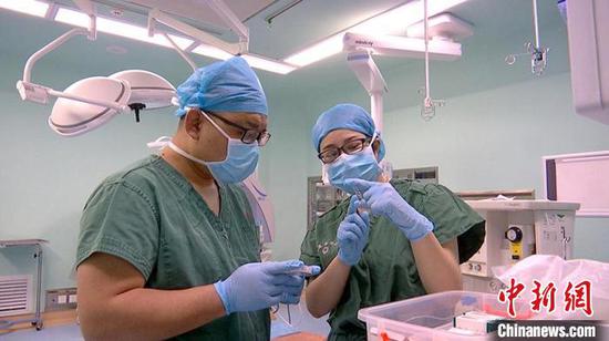 陆蓉（右）正在给徒弟李超讲解手术麻醉过程中的应急抢救用药知识。　李桃　摄