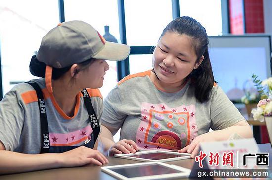 “天使”员工李小丽和覃婉珍用写字板分享着平时的兴趣爱好。谈婕  摄