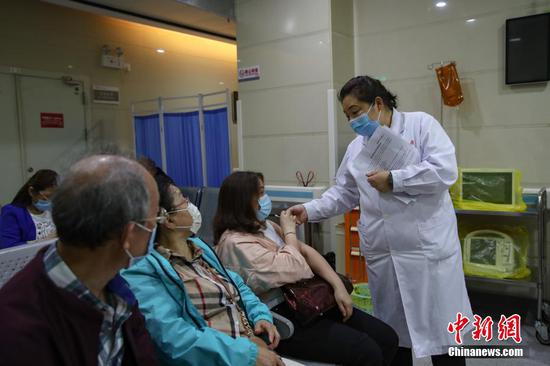 5月20日，贵州贵阳，医护人员在贵州省人民医院新冠疫苗接种点留观区给市民讲解须知。 瞿宏伦 摄