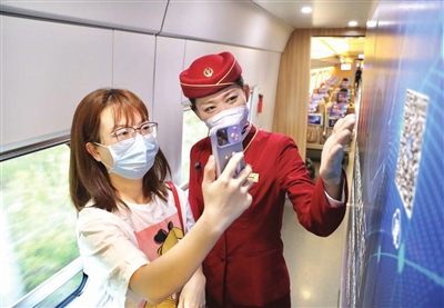 乘客通过手机扫描京津城际主题列车上的二维码，了解世界智能大会。潘立峰 摄
