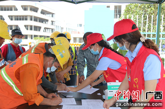 志愿者指导工人预约疫苗接种  邹杰 摄