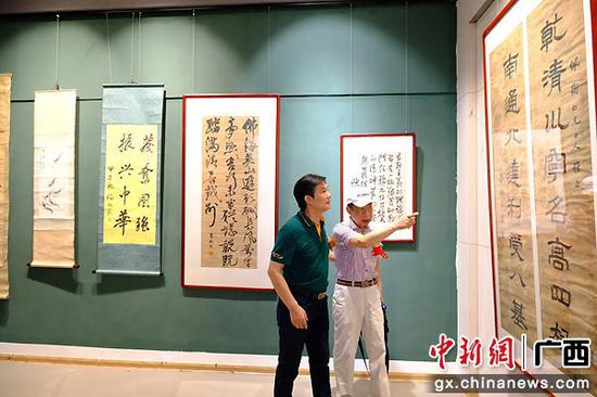 广西东西方美术院院长、著名画家吴学斌（左）参观遗墨展。宋延康 摄