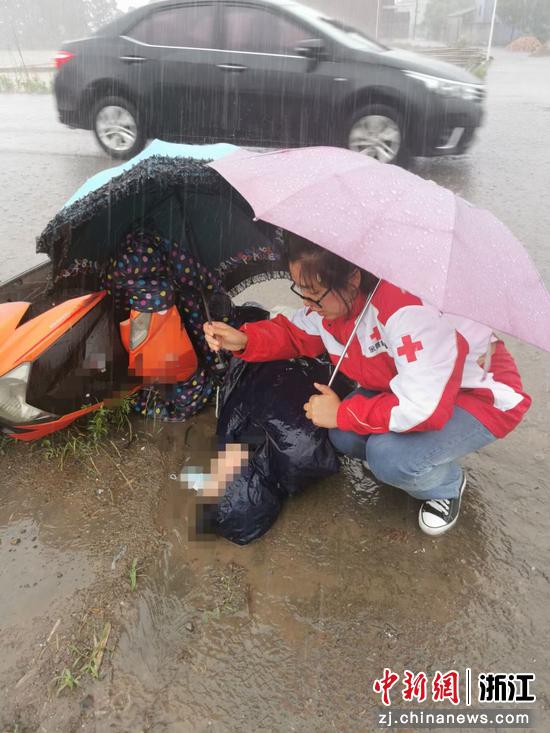 韩丹凤为昏迷女子撑伞遮雨。杨明供图
