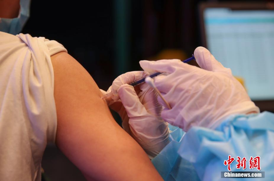 贵州民族大学学生在新冠疫苗接种现场接种疫苗。 瞿宏伦 摄
