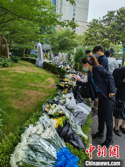 遗体告别仪式前，民众自发送来的花圈花束已经摆满龙华殡仪馆大厅前的绿篱。　陈静 摄