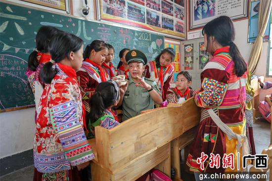 武警官兵为红瑶女童讲起红船的故事。李灿明 摄