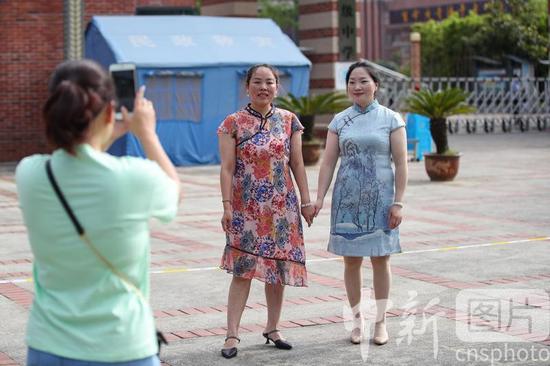6月7日，贵州省遵义市汇川区遵义航天高级中学考点，考生家长穿着旗袍在考场外合影。当日，2021年中国高考拉开大幕。 中新社记者 瞿宏伦 摄