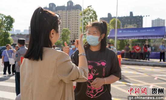 6月7日，在贵州省铜仁市万山区铜仁六中考点，一名家长给考生加油打气。