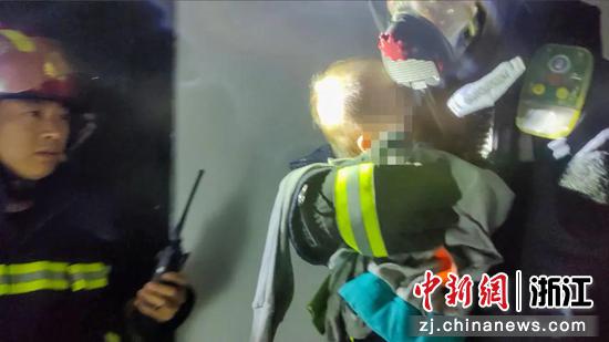 一名消防员救出火场被困幼童。吴佳东 摄