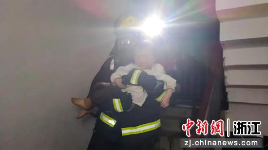 一名消防员救出火场被困幼童。吴佳东 摄