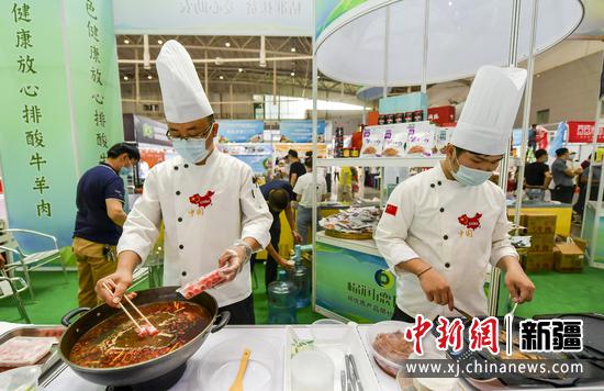 图为两位厨师现场烹饪美食。 中新社记者 刘新 摄