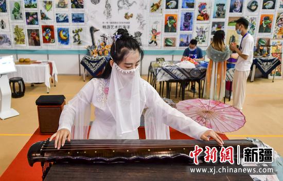 图为传统文化展示区，工作人员身着汉服演奏古筝，为本届展会助阵。   中新社记者 刘新 摄