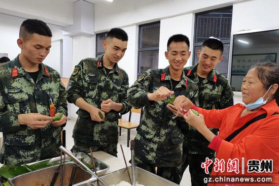 贵阳支队的官兵邀请社区居民参与包粽子活动。