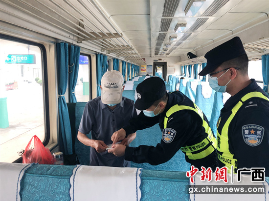 民警在火车上嘱咐老人注意事项 崇左警方供图 民警在火车上嘱咐老人注意事项 崇左警方供图