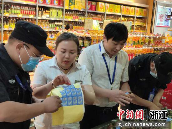 民警在超市张贴反诈宣传单。金仙云 摄