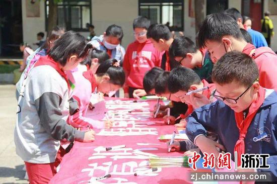 工作人员号召师生加入“扫黄打非”专项行动中，学生们在横幅上签名。裘寿倩 摄