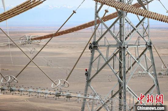 国网新疆电力有限公司带电作业人员正在登塔。　张利民 摄