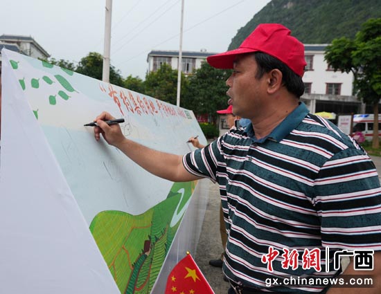 群众纷纷在“节约集约用地 严守耕地红线”签名墙上签名。